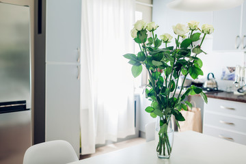 Mother's day present. Bouquet of roses on kitchen. Modern kitchen design. Interior of kitchen decorated with flowers.