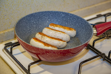 Appetizing ruddy juicy Munich sausages fried in a pan. Bavarian food style