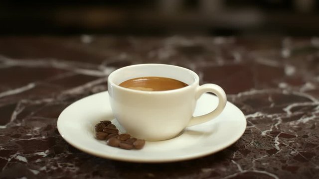 barista serves espresso in a white bowl with grain on a dish