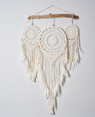 Three beautiful white dream catcher on the light color wall. Boho handmade style decor.