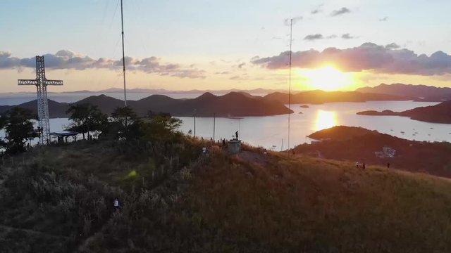 Aerial, pull back, drone shot away from people on the top of Mount Tapyas, on the Coron island, during sundown, in Philippines, Asia