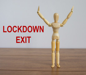 COVID-19 Pandemic Coronavirus and business concept. Wooden model of a man. Inscription 'lockdown exit'.