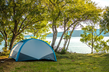 Pitched Tent In Campsite Close To Lake And Mountains.
