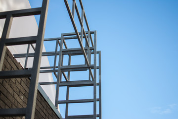 metal structures made of pipes of a building under construction against the blue sky