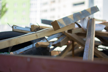 a litterless metal container without a cover is full of construction debris and waste standing in...