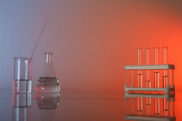 Fototapeta na wymiar conceptual background with chemical flasks and lab glassware. lab glassware on glass table with copy space.