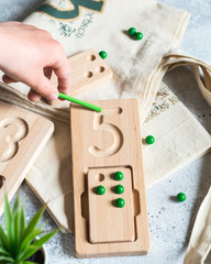 Fototapeta na wymiar Wooden counting and writing trays - learning resource for educating littles on number writing, fine motor skills, hand eye coordination, mathematical skills. Montessori materials. Counting game