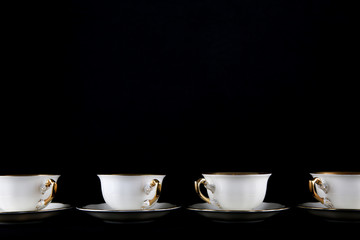 vintage porcelain cups on black background with copy space