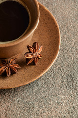 
Brown cup of coffee with a saucer and anise