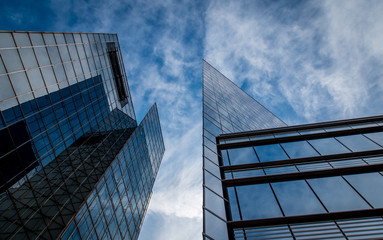 Fototapeta na wymiar Tall glass skyscrapers against a blue sky with white clouds