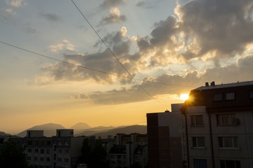 Sunrise and sunset, beautiful clouds over the meadow, hills and buildings in the town. Slovakia