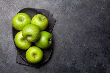Ripe green apple fruits on dark stone table