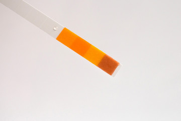 Closeup of a used pH paper test strip. Visual color laboratory test for testing liquids.