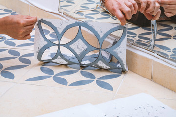 Stay at home and home improvement concept: Close up of hands removing a decorative painting stencil...