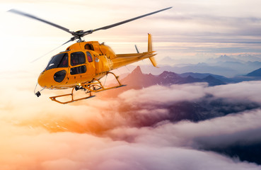 Yellow Helicopter flying over the Rocky Mountains during a sunny sunset. Aerial Landscape from British Columbia, Canada near Vancouver. Composite