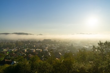 Sunrise and sunset, beautiful clouds over the meadow, hills and buildings in the town. Slovakia