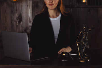 Lawyer office. Statue of Justice with scales and lawyer working on a laptop. Legal law, advice and justice concept.
