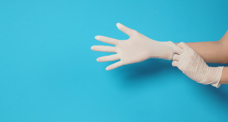 Two hand wearing white gloves and left hand is pulling.Put on blue background.