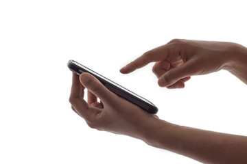 Delicadas manos apuntan a un teléfono móvil. Imagen horizontal con contraste, fondo blanco. 