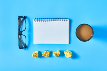 Office workplace with different accessories, tools and gadgets on blue table. Business concept. Top view