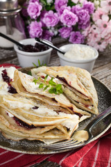 Crepes with ricotta cheese and blackcurrant jam.