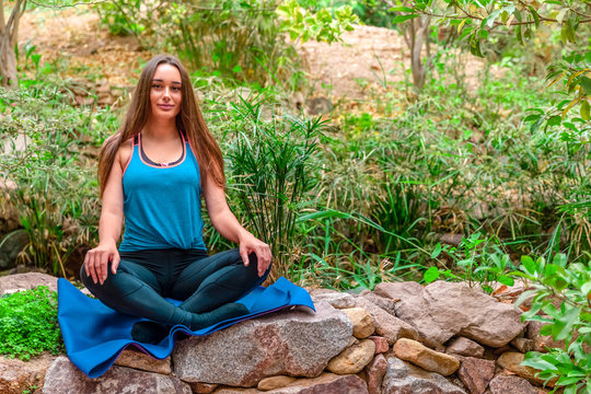Young woman practicing yoga in the parck