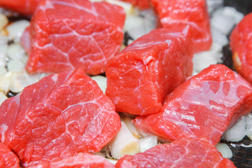 red meat in a pan with onions