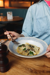 woman holding a plate of ravioli