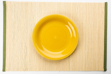 Empty Yellow plate on a bamboo napkin,top view