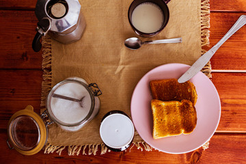 Desayuno con leche, cafe, azúcar, pan tostado y mermelada