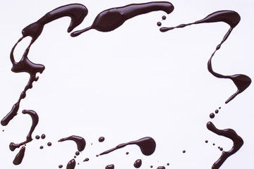light gray background with a frame of spilled liquid chocolad, place for text