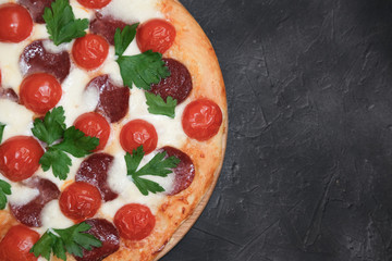 Traditional italian pizza pepperoni with salami and Mozzarella on a dark background. Italian cuisine concept. top view, copy space for text