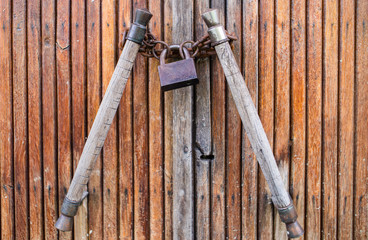 old wooden door locked with rusty chain and lock