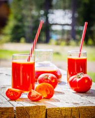 tomato juice and fresh tomato on wooden background