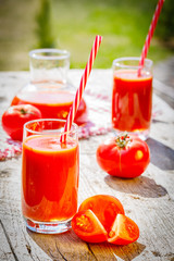 Fototapeta na wymiar tomato juice and fresh tomato on wooden background