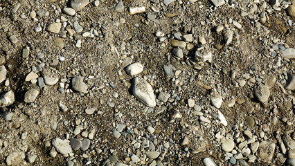 Texture background brown stones on a black earth background. Image of broken stones and gravel. Close up