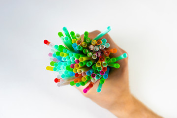 Closeup of bright colorful single use disposable plastic straw bunch isolated on black background