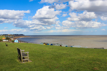 view of the beach and sea with bench looking over