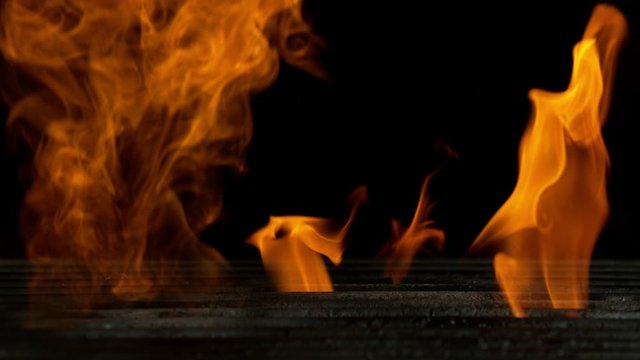 Super slow motion of empty grill grid with fire on black background. Filmed on high speed cinema camera, 1000 fps