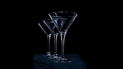 Empty martini glasses on a black.