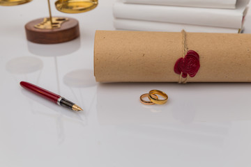 Divorce concept. Golden rings on the table with wooden hammer and money.