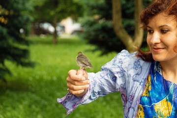 woman with a small bird. bird in hand.