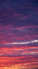 Naklejka na ściany i meble Amazing nature background: dramatic and moody pink, purple and blue cloudy sunset sky shot vertical