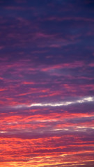 Amazing nature background: dramatic and moody pink, purple and blue cloudy sunset sky shot vertical