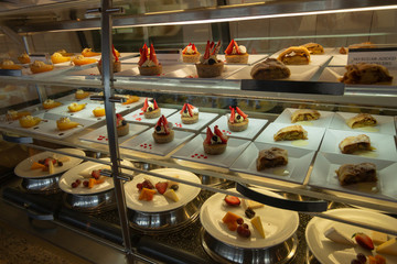 Fruit cakes  in a restaurant.Cakes under the glass. Sweets in the dining room. Sweets at the hotel. Bakery products.