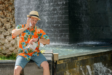 Stressed young tourist man wiping sweat in the city outdoors