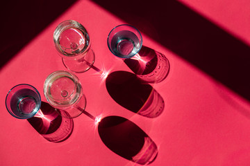 Four glasses with wine on a pink background