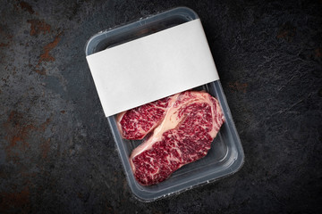 Raw Wagyu marbled beef steak in vacuum packaging, logo mockup for design