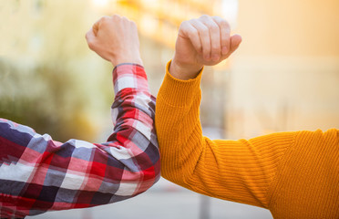 Elbows bump. Health care concept. Social distancing. Two people bump elbows to avoid coronavirus outdoors. Coronavirus epidemic. Closeup elbow bump