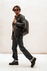 Curly and serious caucasian man posing in a bright studio on a white background, wearing casual and...